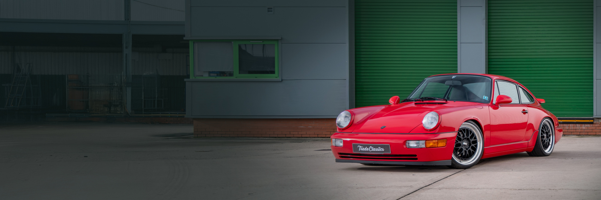 Porsche 911 964 parked outside a workshop